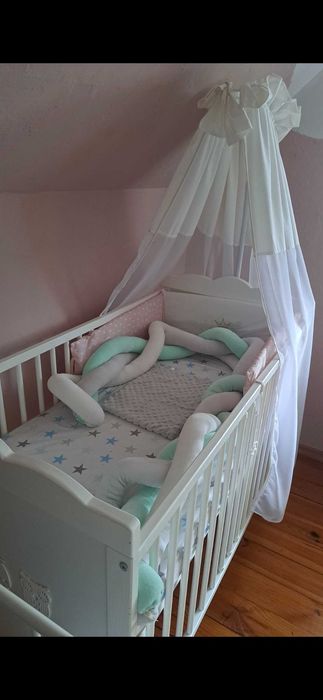 Solidne, białe łóżeczko dziecięce z baldachem.