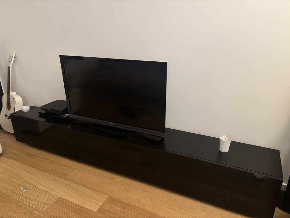 Movel tv preto com portas revestidas a vidro com gavetas