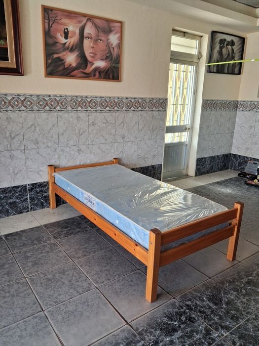 Cama de solteiro com estado e colchão.