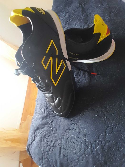 chuteira New Balance Furon V8 Elite TF (ou da versão Team correspondente), especificamente desenhada com uma sola TF (Turf) para relva sintética.