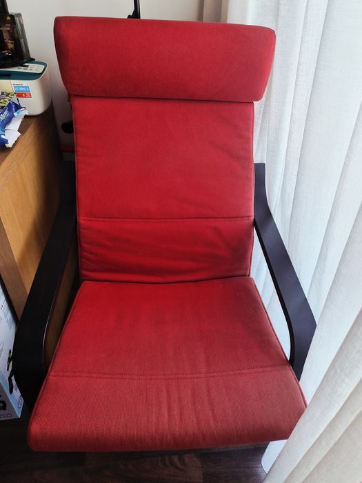 Poltrona IKEA POÄNG com uma estrutura de madeira escura e almodas