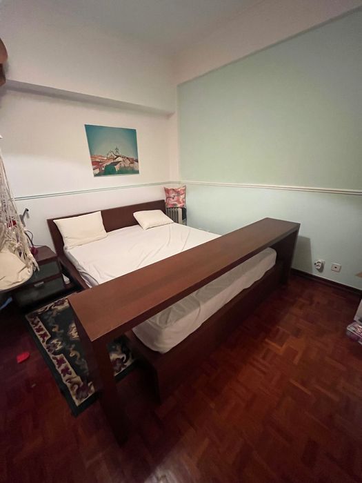 Cama de casal com mesa de cabeceira e apoio