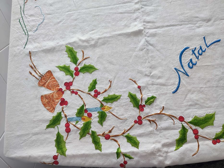 Toalha de natal branca com bordados natalícios.