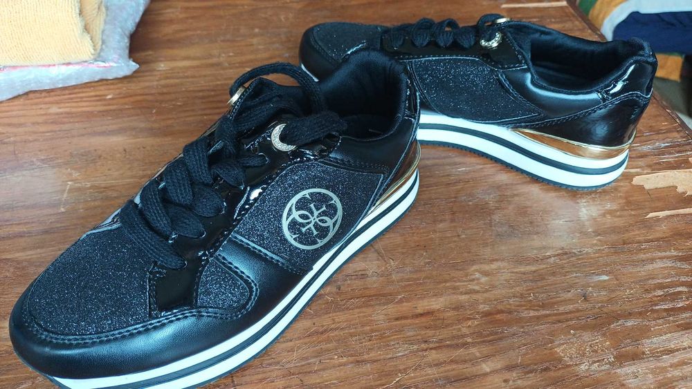 Marca GUESS, ténis pretos com em pele com aplicações dourada