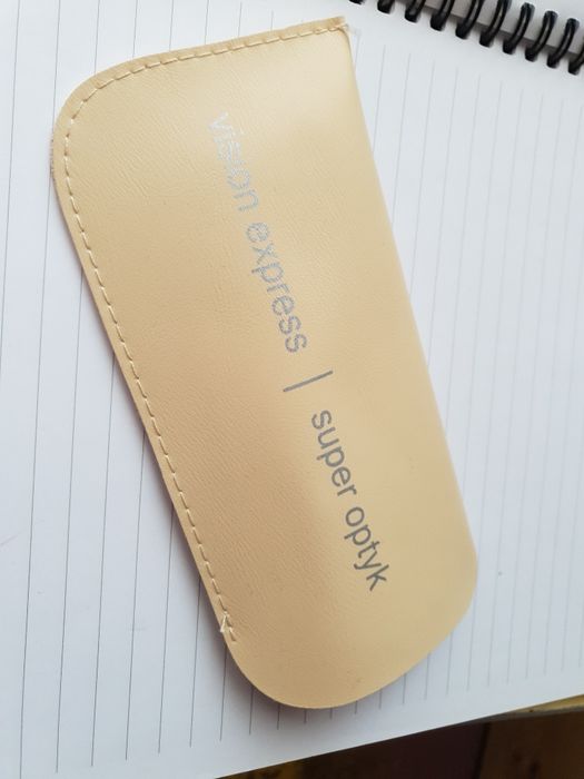 Etui na okulary z miękkiego materiału w kolorze beżowym, z wytłoczonym lub nadrukowanym logo sieci Vision Express super optyk