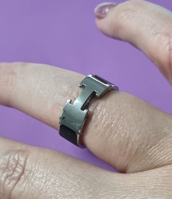 Anel preto e prateado, em aço inoxidável, com letra "H". T17