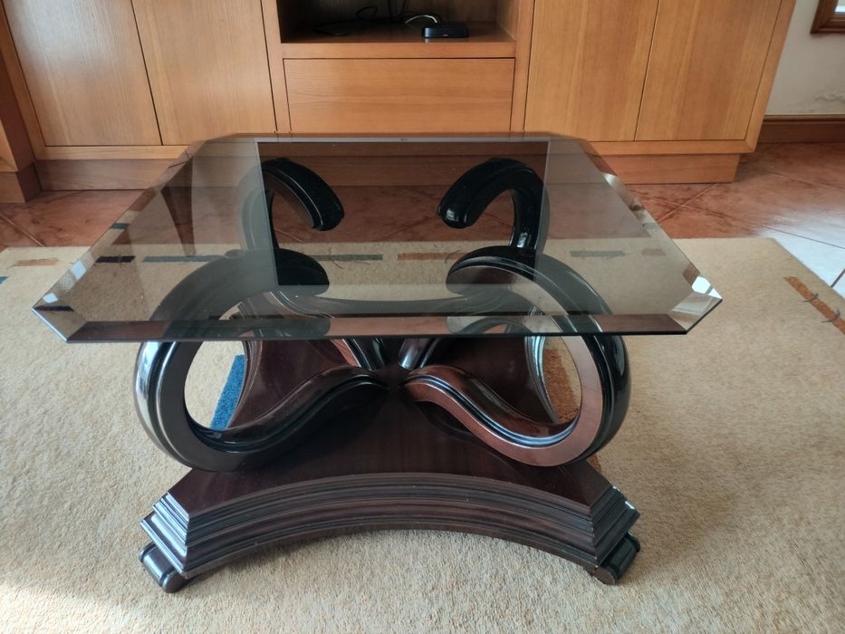 Mesa de centro centro com pés em madeira e tampo em vidro .