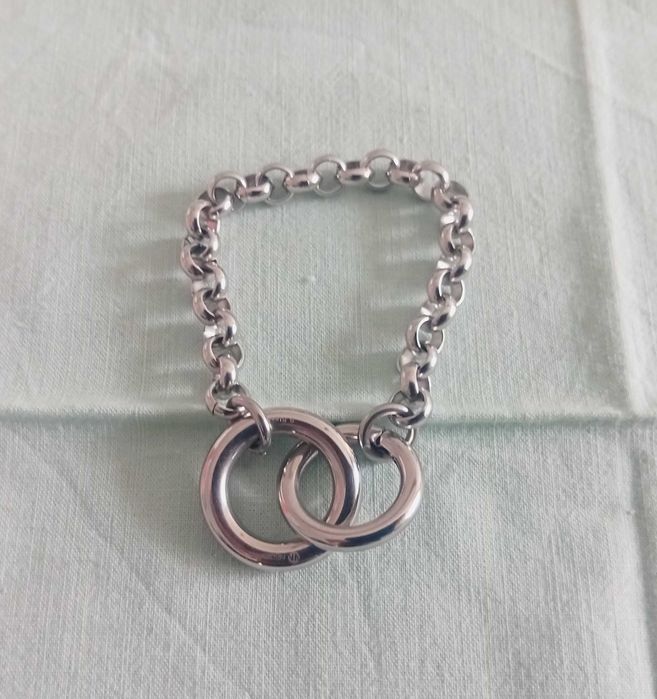 Pulseira em metal prateado, com aros e 2 argolas