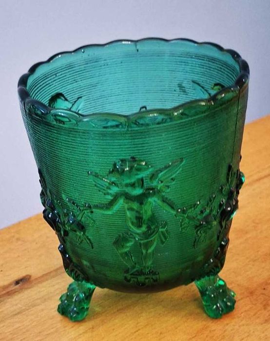 Pote em vidro verde com decoração de querubins