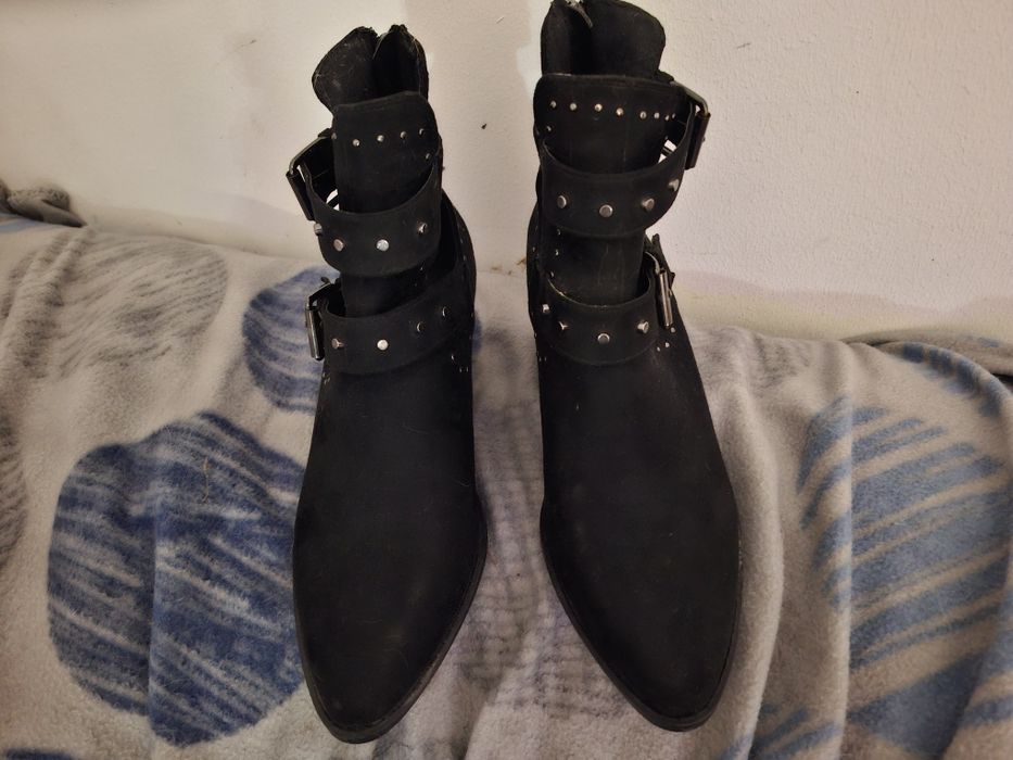 Botas pretas com fivelas e pitons