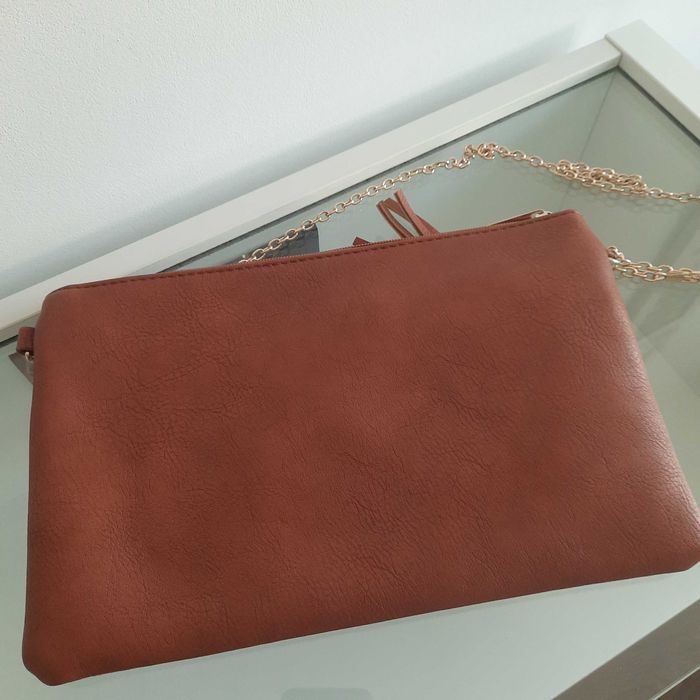 Pochete muito gira com corrente dourada na alsa