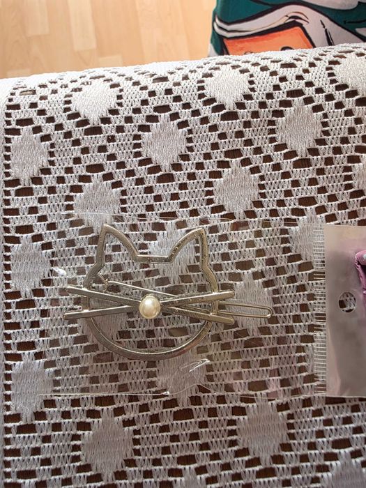 spinka do włosów w kształcie głowy kota z perłą.