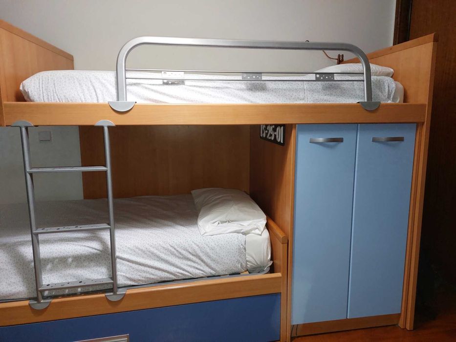 Quarto com três camas, comodas, guarda roupas e estantes