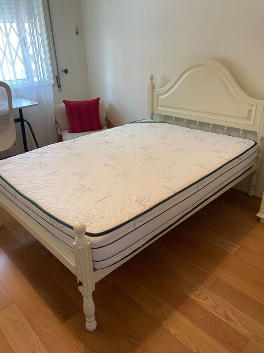 Cama lacada de branco e colchão ortopédico