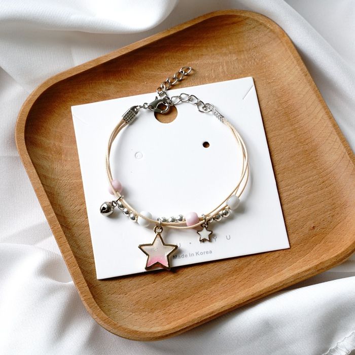 Pulseira/tornozeleira estrelas em tons de lilás, azul e rosa.
