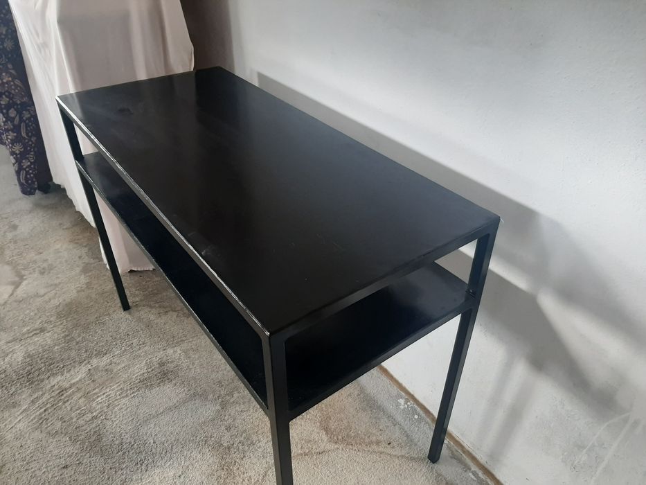 Consola em metal com uma prateleira.