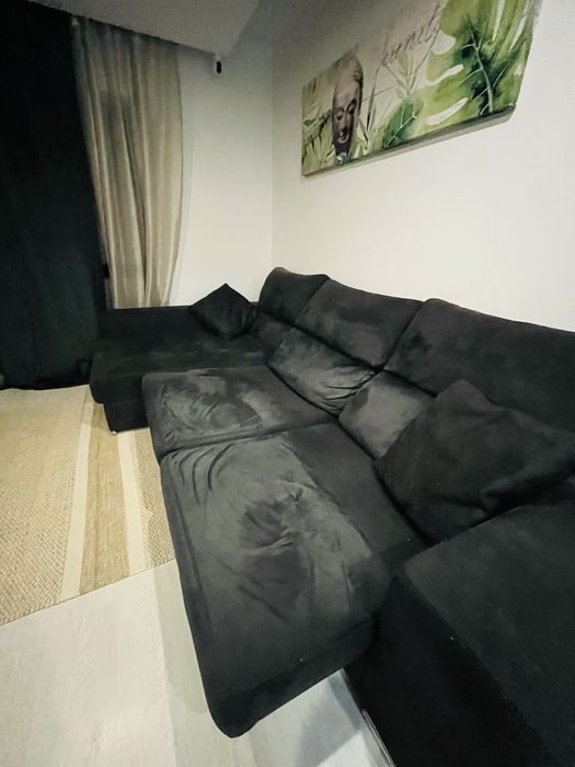 Sofá preto chaise longue, com arrumacão e 2 bancos