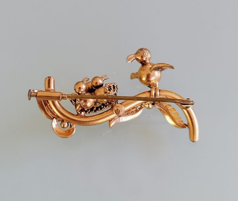 Lindo broche antigo em latão. Pássaros num ninho.