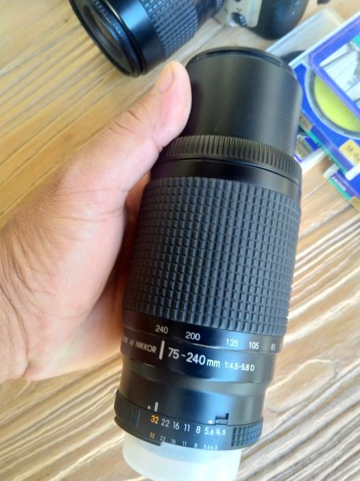 Nikon F60 com teleobjetiva, filtros, rolos