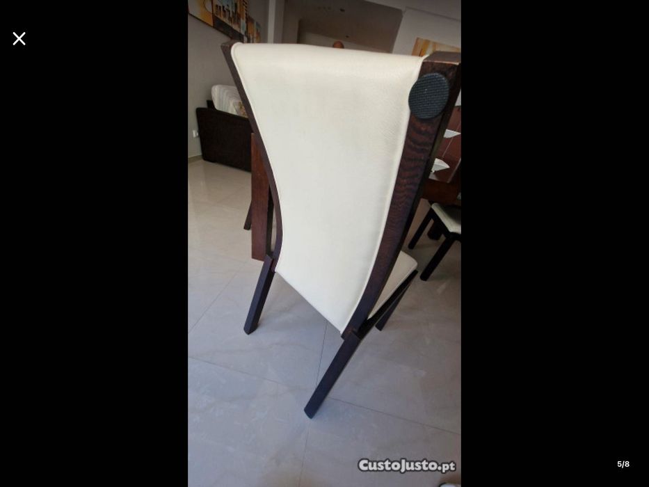 Conjunto de móveis de sala com mesa e cadeiras de pele.