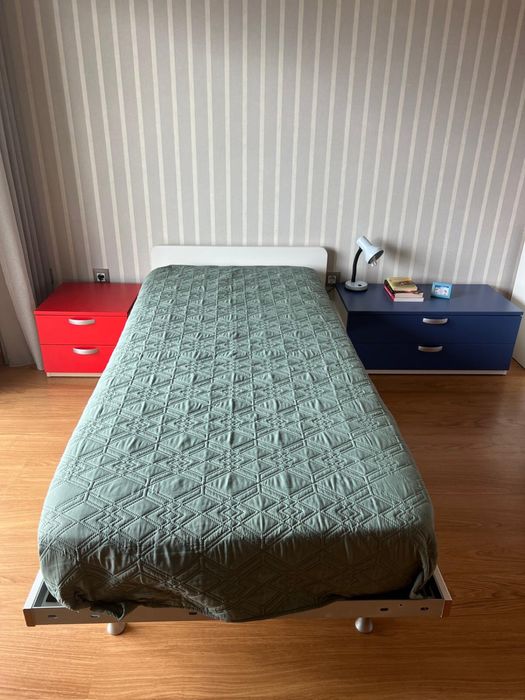 Quarto com cama , mesa de cabeceira e secretaria com estante