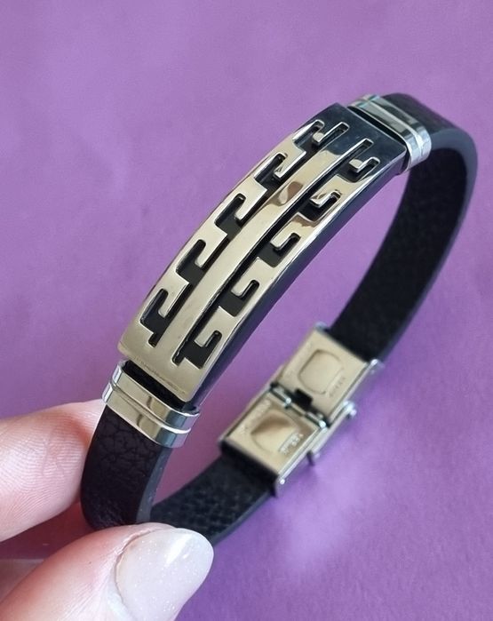 Pulseira de cabedal preto com peças prateadas em aço inoxidável.
