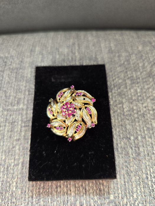 Złota broszka próby 750 z rubinami.