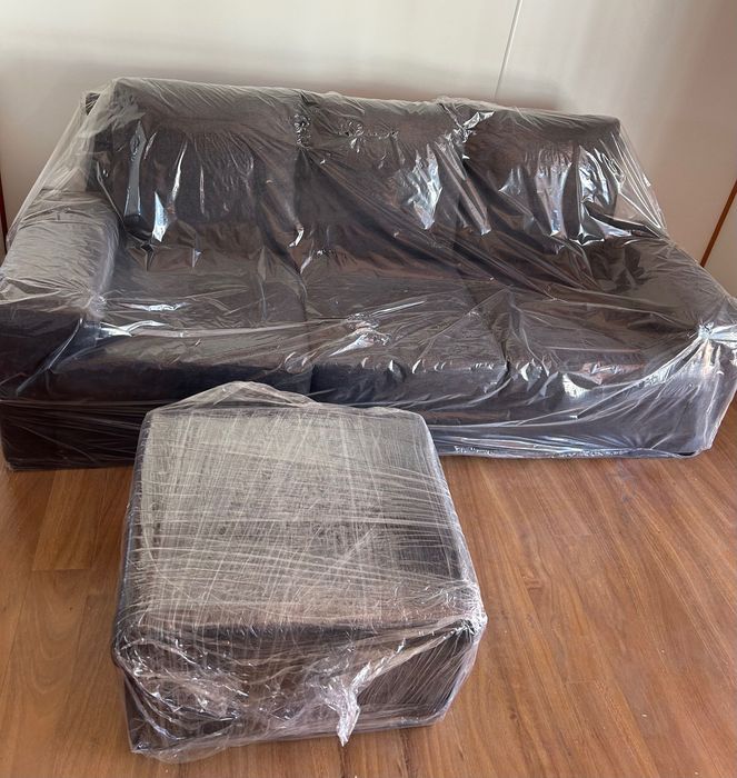 Sofá preto de 3 lugares com apoio de pés