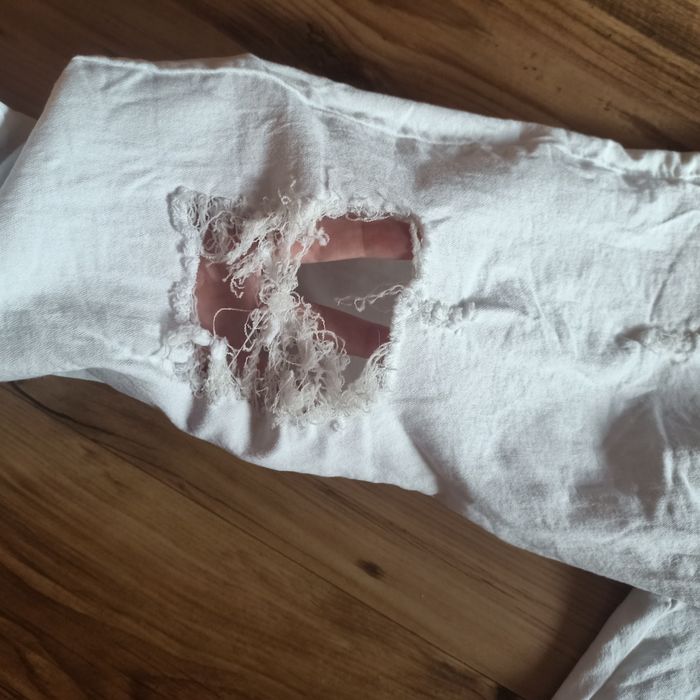 Białe szerokie spodnie z dziurami