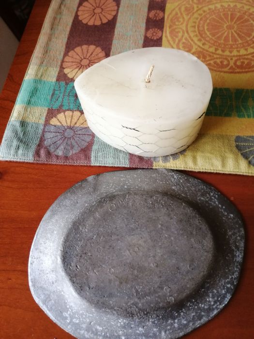 Vela branca rodeada com metal e com suporte metálico