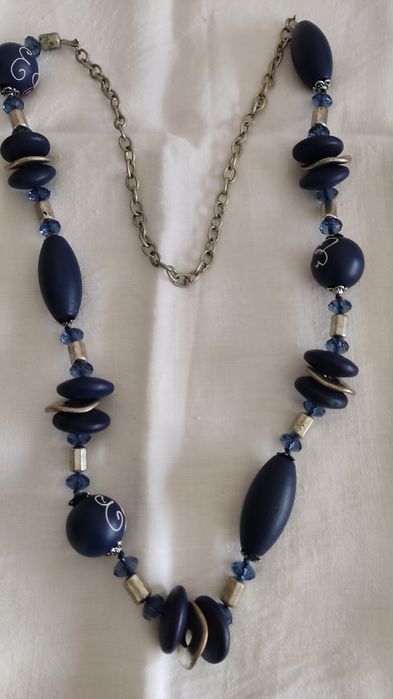 Colar  azul com desenhos em algumas contas.