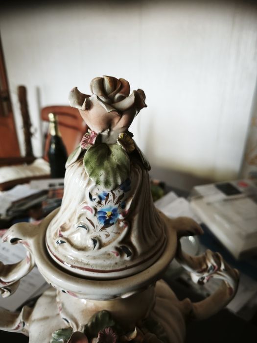 peça cerâmica decorativa ou uma peça de porcelana. Tem a forma de um vaso ou urna com duas pegas, com uma tampa separada
