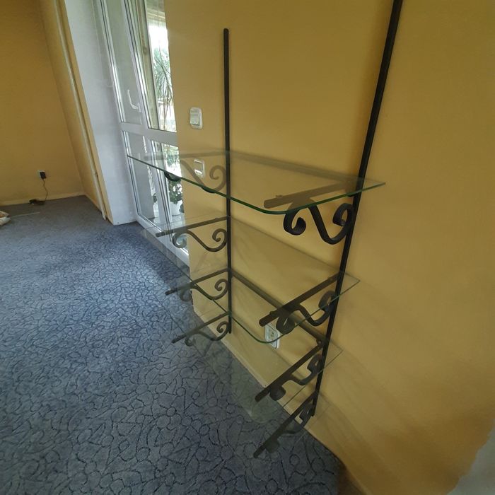 Metalowa półka z szklanymi szybami.