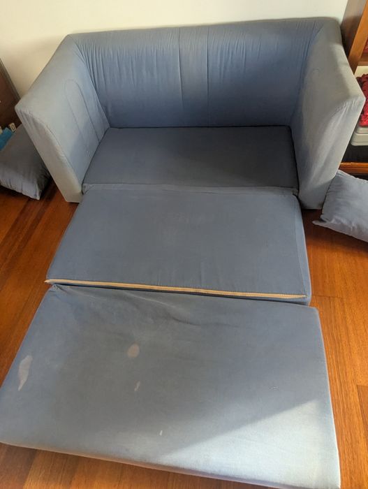 Sofá cama azul com algumas manchas