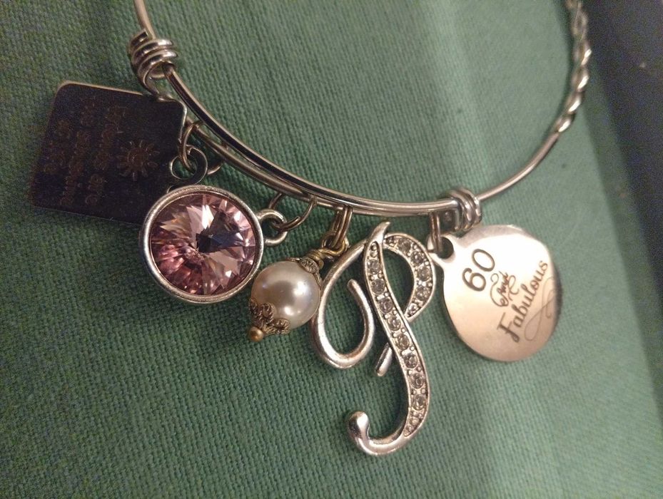 Pulseira em aço inoxidável, com vários berloques temáticos (charm bracelet)
