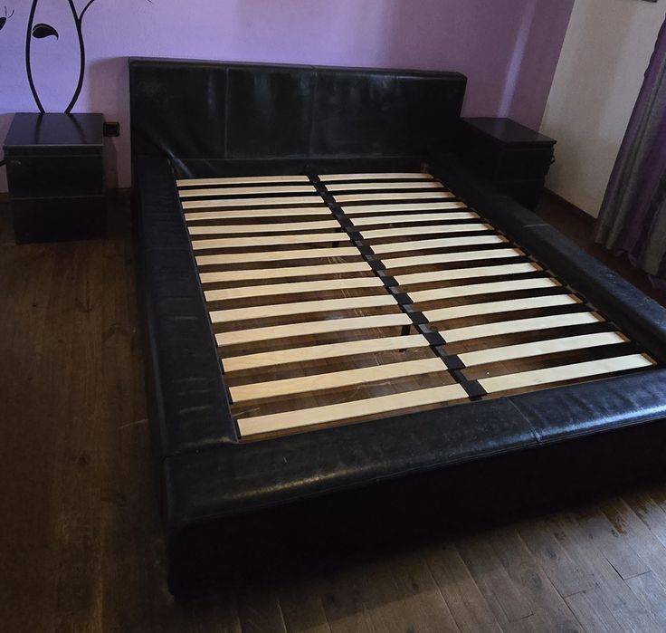 Cama preta com 2 mesas de cabeceira