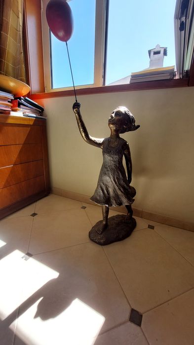 Escultura de menina com balão