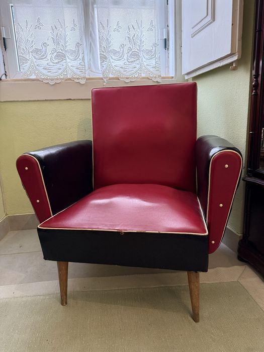 Cadeira de braços vintage em couro vermelho e preto.