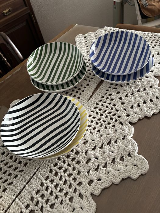 Meio serviço de jantar, 6 pratos de mesa, 6 pratos de sopa e 6 pratos de sobremesa de varias cores: amarelo, azul, verde e preto.