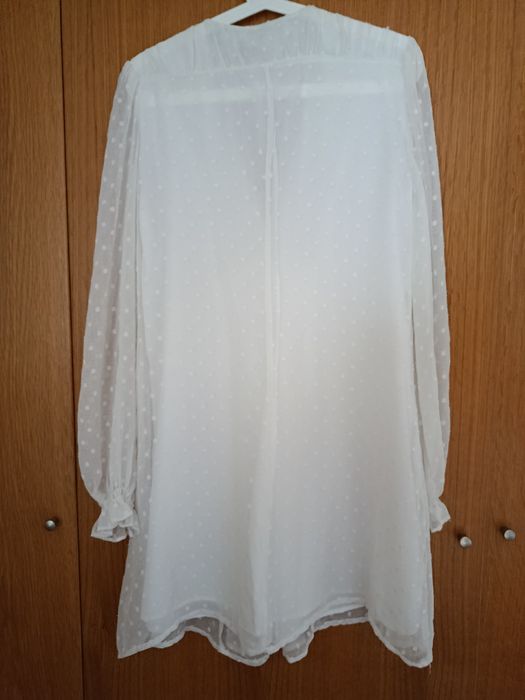 Vestido branco decote em V
Camada exterior com detalhes e folhos
Forro