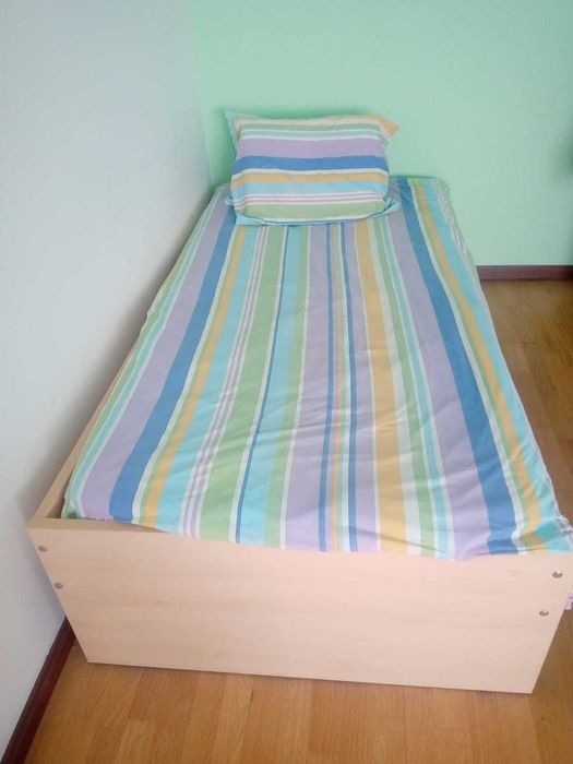 Cama em madeira e cabeceira com oferta de roupa da cama