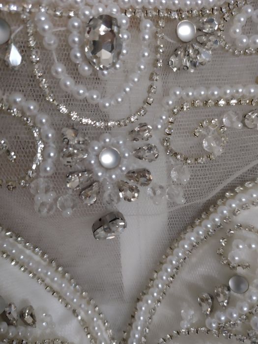 Suknia ślubna bogato zdobiona na lekkim rękawku