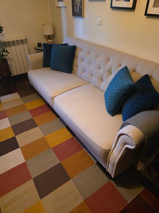 Sofá cama, tapete e almofadas decorativas