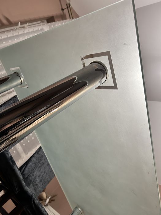 Szklany stół z metalowymi nogami