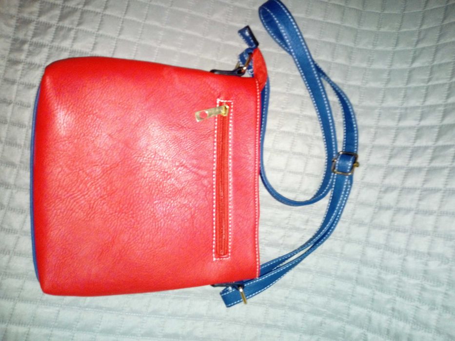 Mala vermelha, azul escuro e branca, com diversas bolsas.