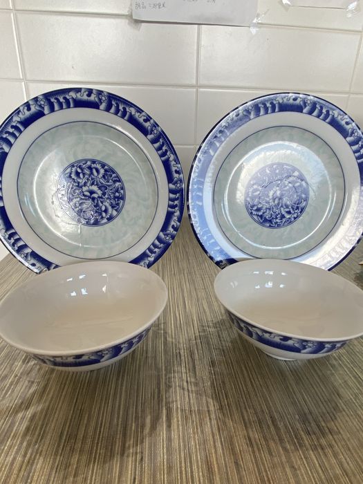 Dois pares de pratos e taças em porcelana azul e branca.