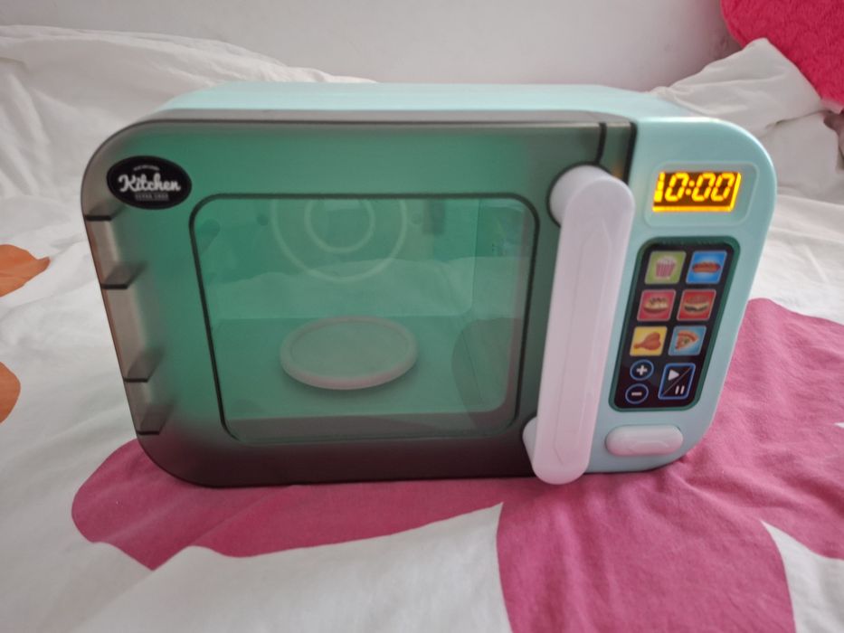 Microondas de brinquedo e loiça de brincar.