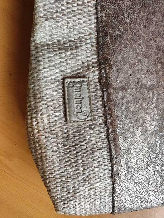 Bolsa de mão prateada com lantejoulas e acabamento em ráfia.