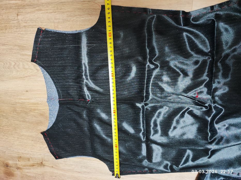 Недошита сукня з блискучої стальної тканини.