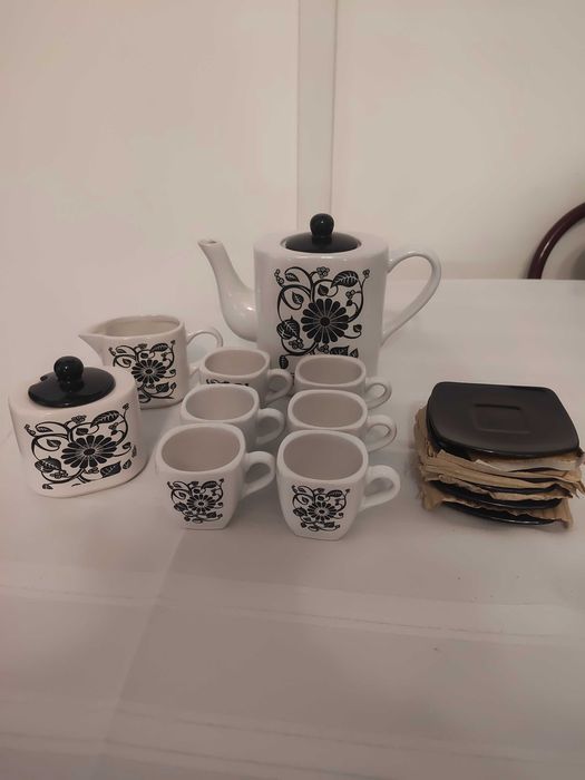 Conjunto elegante de chávenas e pires com um padrão floral a preto e branco.